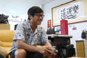 雷總背後掛著斗大的「樂逍遙」字畫。